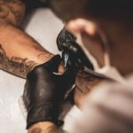 Tattoo - shallow focus photo of person tattooing person's right arm