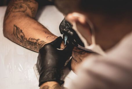 Tattoo - shallow focus photo of person tattooing person's right arm