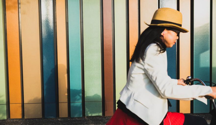 Cycling In Japan - woman wearing white blazer and brown hat riding bicycle