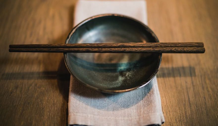 Chopstick - pair of brown chopsticks on round ceramic bowl