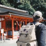 Travel Japan - man wearing black top and backpack near orange structure