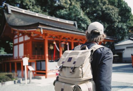 Travel Japan - man wearing black top and backpack near orange structure