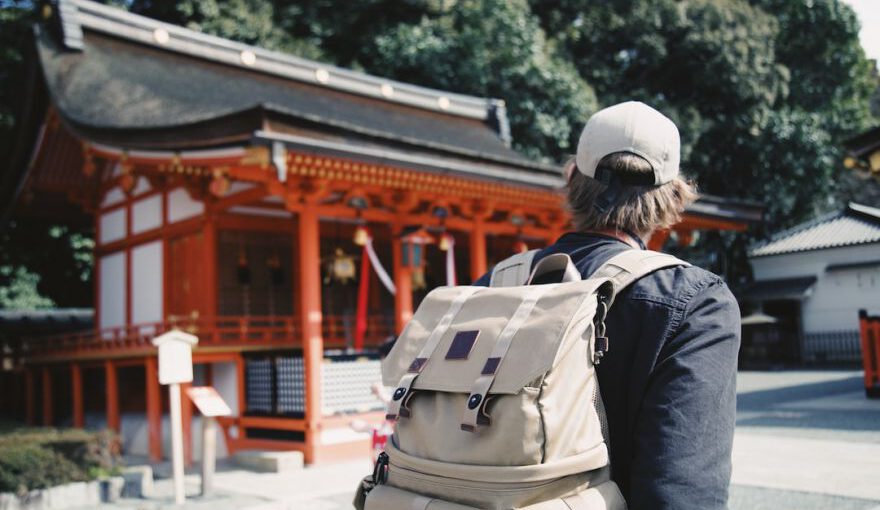 Travel Japan - man wearing black top and backpack near orange structure
