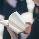 Learn Japanese - standing woman reading book at daytime