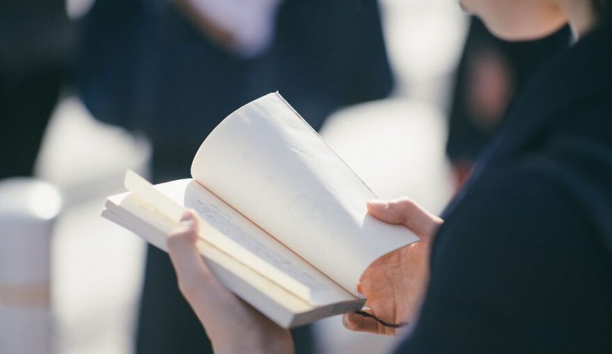 Learn Japanese - standing woman reading book at daytime