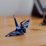 Japanese Crafts - a blue origami bird sitting on top of a wooden table