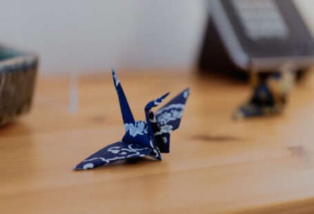 Japanese Crafts - a blue origami bird sitting on top of a wooden table