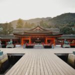 Shinto - brown wooden gazebo near green trees during daytime