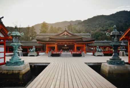 Shinto - brown wooden gazebo near green trees during daytime