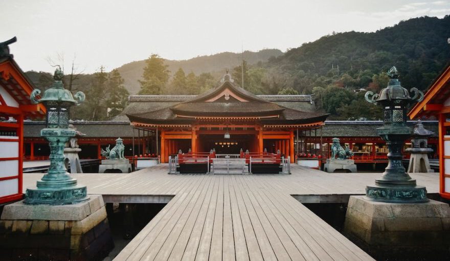 Shinto - brown wooden gazebo near green trees during daytime