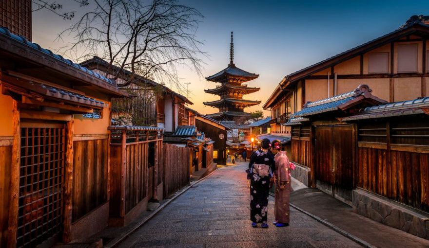 Japanese Culture - two women in purple and pink kimono standing on street