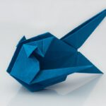 Japanese Origami - a blue origami bird sitting on top of a table