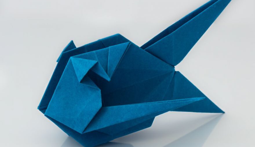 Japanese Origami - a blue origami bird sitting on top of a table