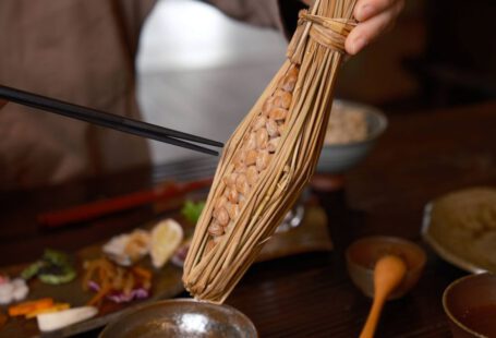 Japanese Breakfast - a person holding a stick over a bowl of food