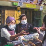 Japanese Masks - two vendors accommodating customer